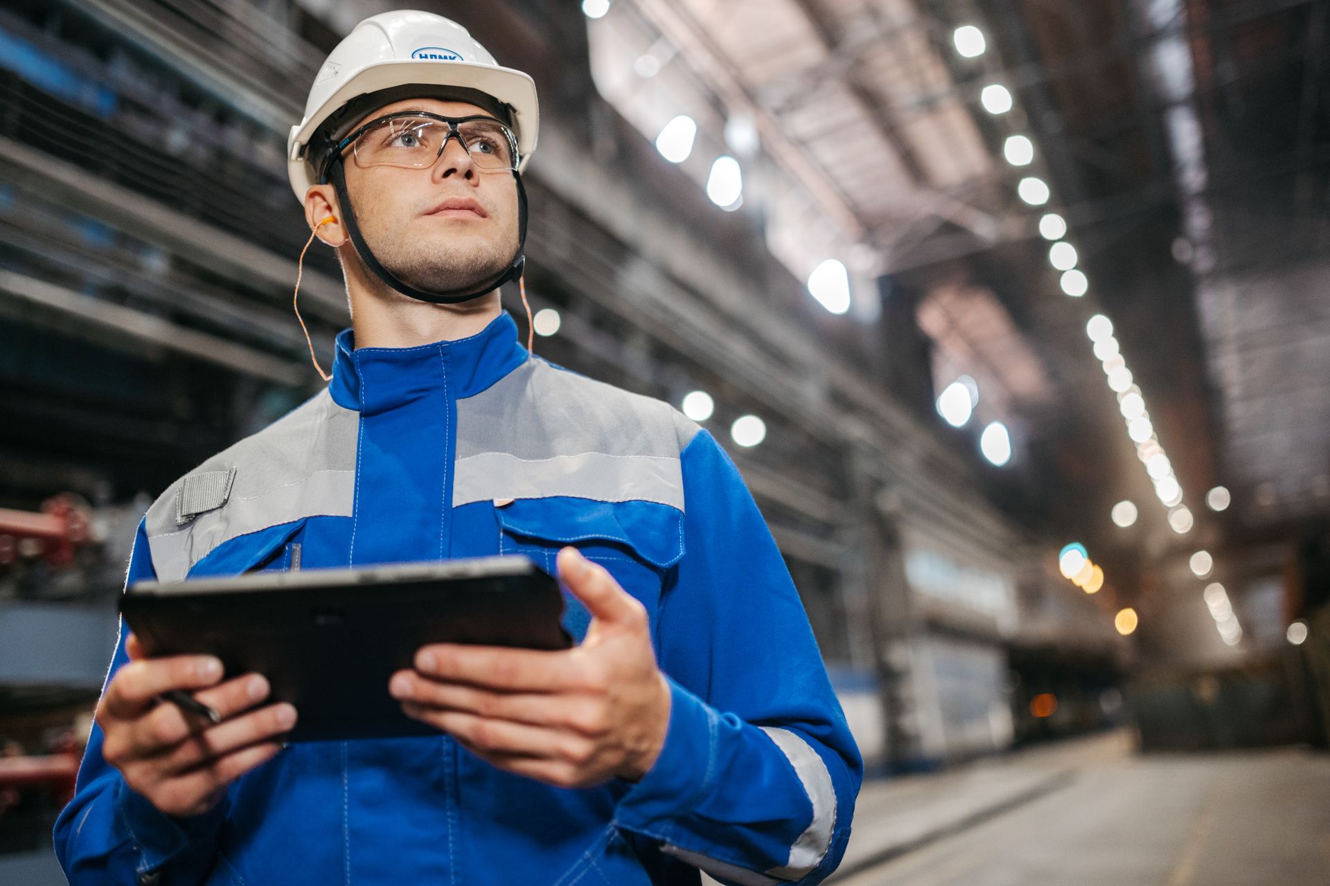 Trabajadora industrial con uniforme, casco y EPP en planta